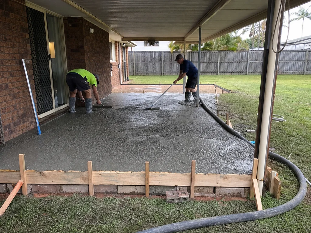 Concreters pouring a covered backyard patio