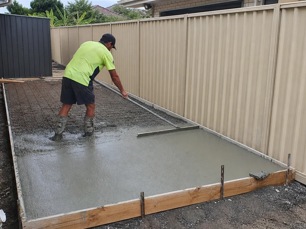 Concreter levelling a backyard shed slab